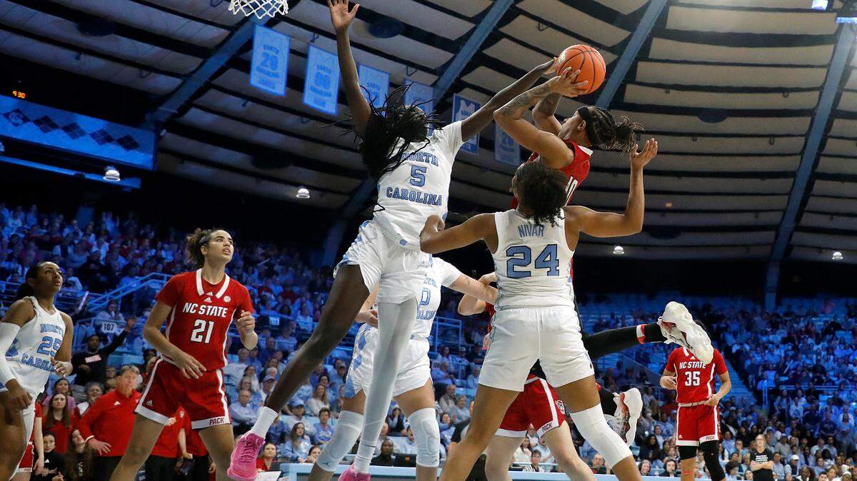 N.C. State’s Aziaha James drives to the basket against North Carolina’s Maria Gakdeng and Indya Nivar during the second half of the Wolfpack’s 80-70 loss on Thursday, Feb. 22, 2024, at Carmichael Arena in Chapel Hill, N.C.
