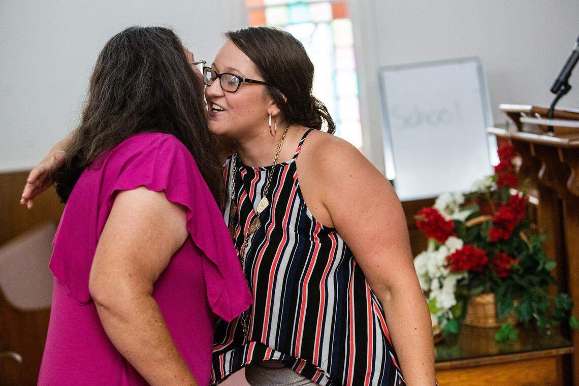 Samantha Brawley, a member of the Eastern Band of Cherokee Indians, right, hugs a woman who was celebrating a milestone in her addiction recovery during a peer support group at Webster Baptist Church in Sylva last year.
