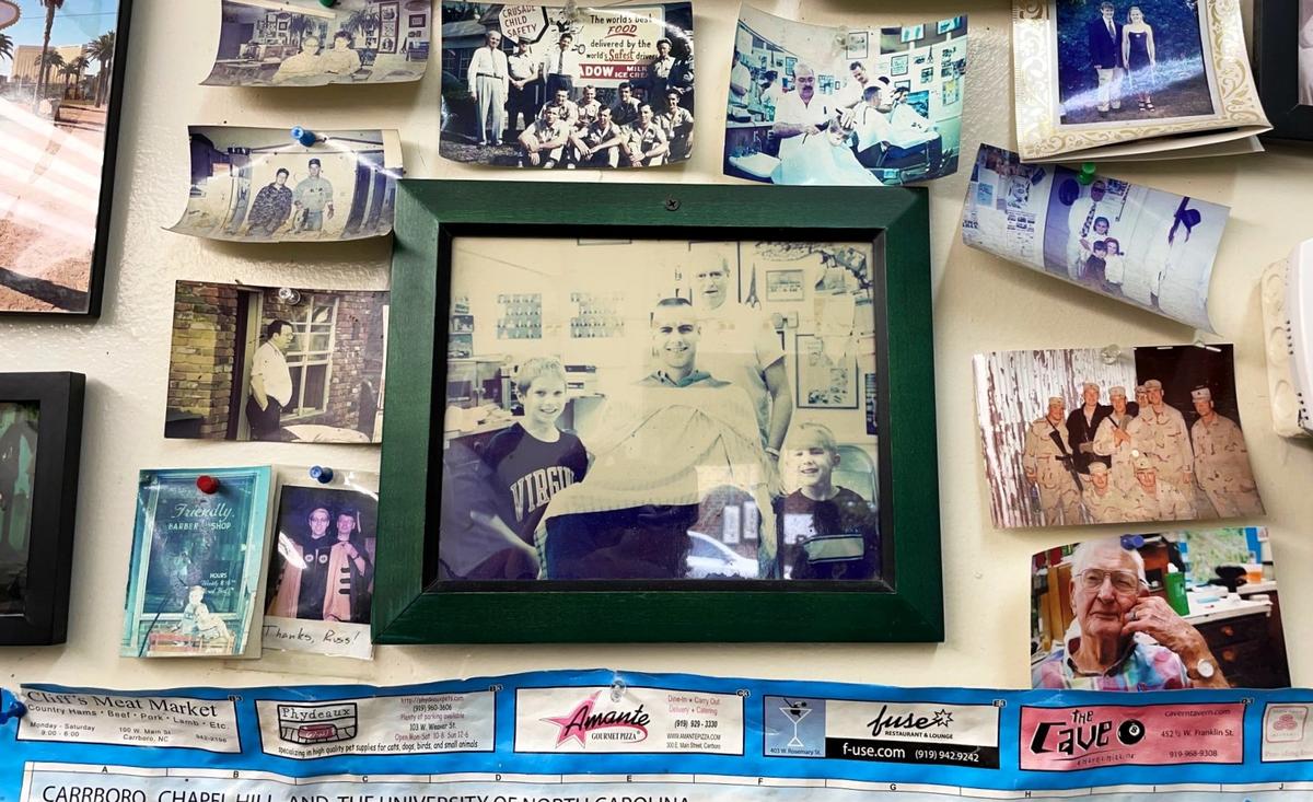 A photo of former UNC Tar Heels center Eric Montross posing with two fans from Statesville, NC, has a central location on the wall of Friendly Barber Shop in Carrboro. Montross, a regular at the shop before his 2023 death, inspired his own signature style.