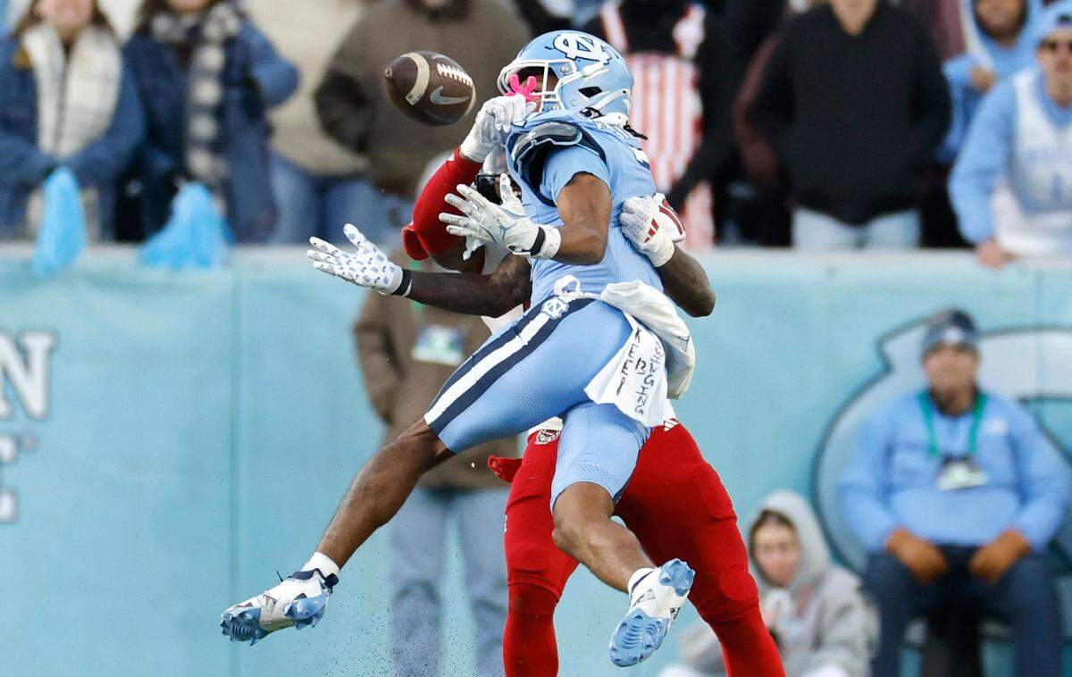 On fourth down, N.C. State cornerback Devon Marshall (16) is called for pass interference on North Carolina wide receiver Christian Hamilton (7) giving the Tar Heels the first down during the first half of N.C. State’s game against UNC at Kenan Stadium in Chapel Hill, N.C., Saturday, Nov. 30, 2024.