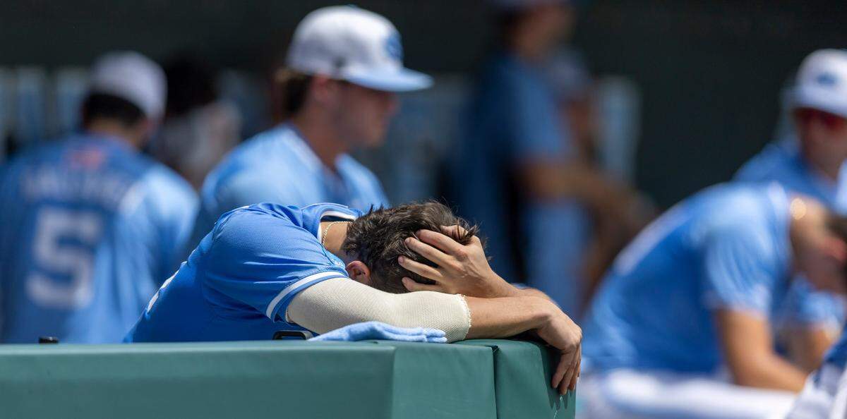 North Carolin catcher Luke Stevenson (44) covers his head in the dugout following the final out, as Arizona hands the Tar Heels a 4-3 defeat, in the NCAA Super Regional final on Sunday, June 8, 2025 at Boshamer Stadium in Chapel Hill, N.C.