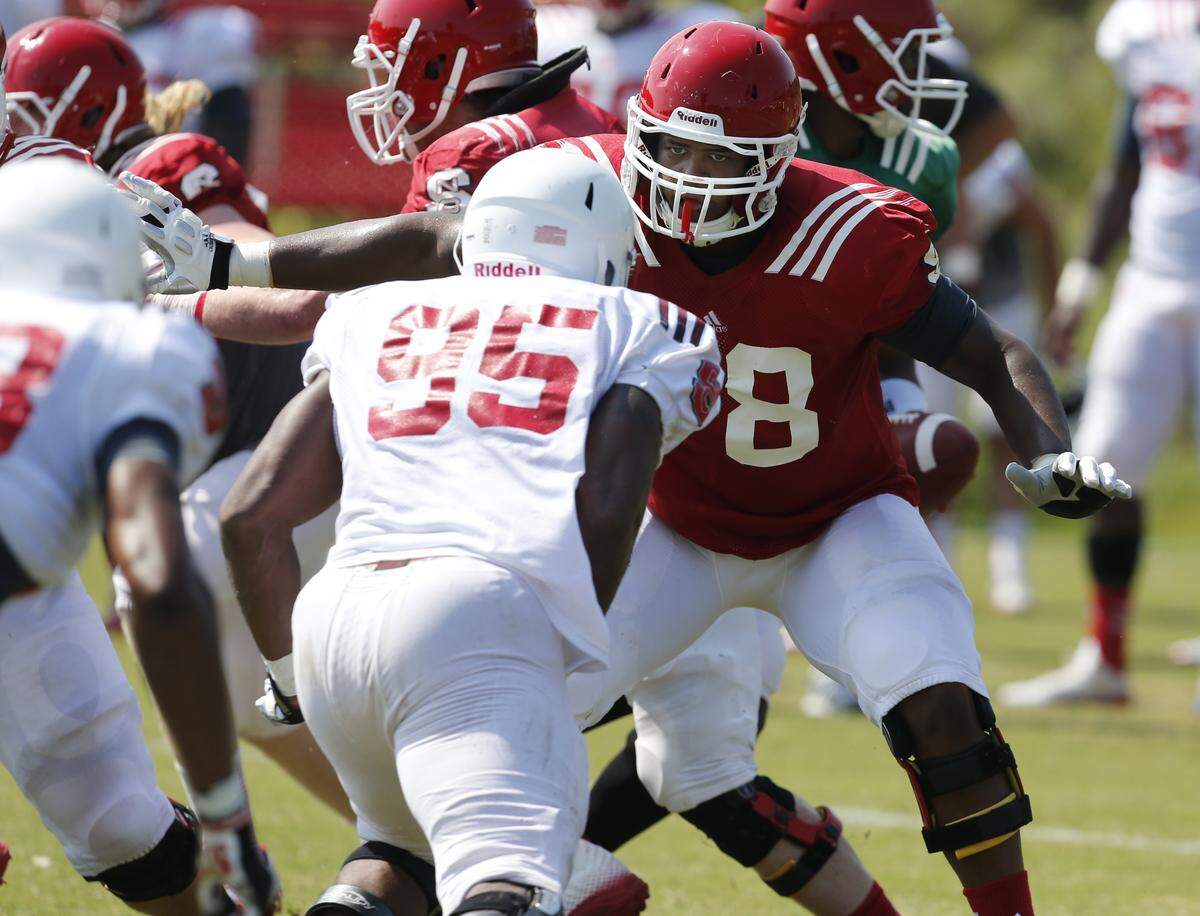 N.C. State offensive tackle Rob Crisp (78) blocks defensive end Art Norman (95) during the Wolfpack’s practice Wednesday, August 6, 2014, at the N.C. State practice fields in Raleigh, N.C. It is the first day for the team in pads.