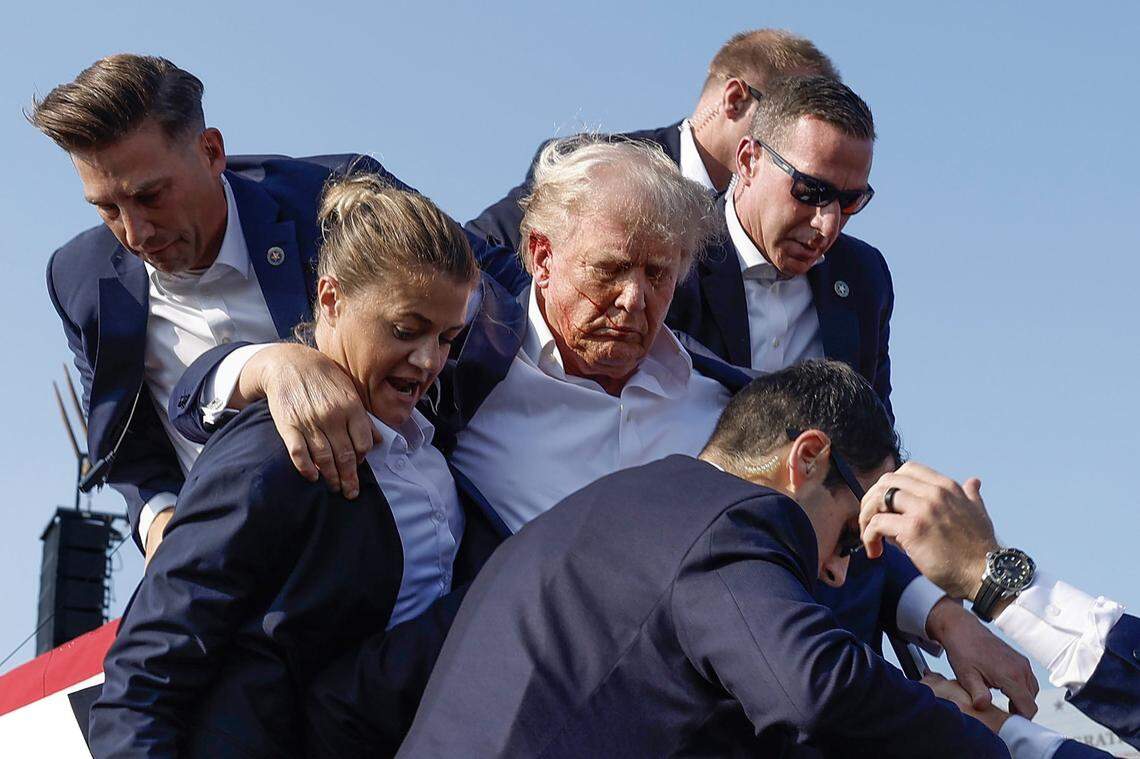 Republican presidential candidate former President Donald Trump is rushed offstage by Secret Service agents after being grazed by a bullet during a campaign rally on Saturday, July 13, 2024, in Butler, Pennsylvania.