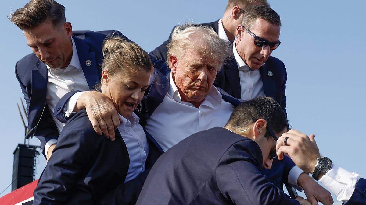 Republican presidential candidate former President Donald Trump is rushed offstage by Secret Service agents after being grazed by a bullet during a campaign rally on Saturday, July 13, 2024, in Butler, Pennsylvania.