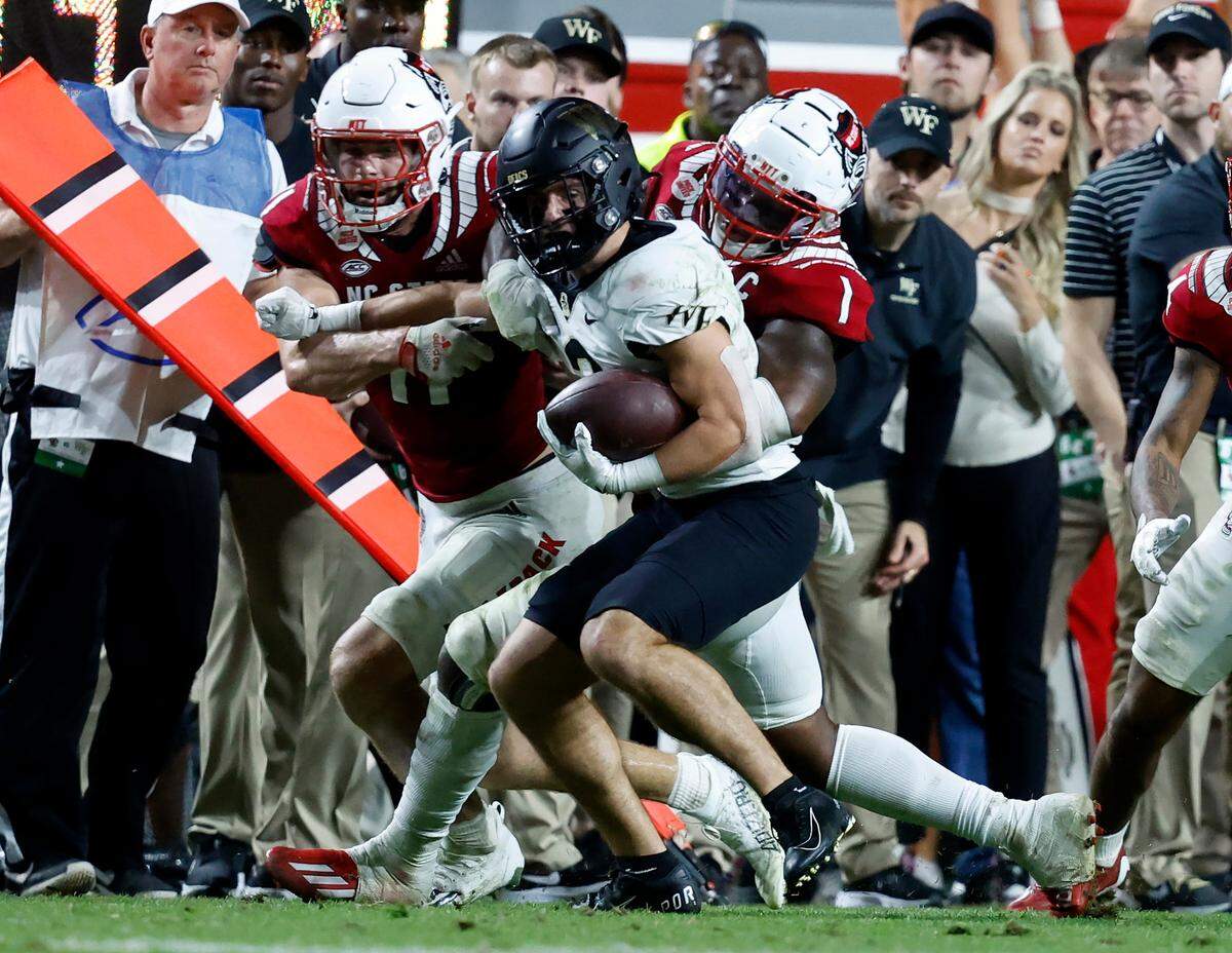 N.C. State’s Isaiah Moore (1) and Payton Wilson (11) stop Wake Forest wide receiver Taylor Morin (2) during the second half of N.C. State’s 30-21 victory over Wake Forest at Carter-Finley Stadium in Raleigh, N.C., Saturday, Nov. 5, 2022.