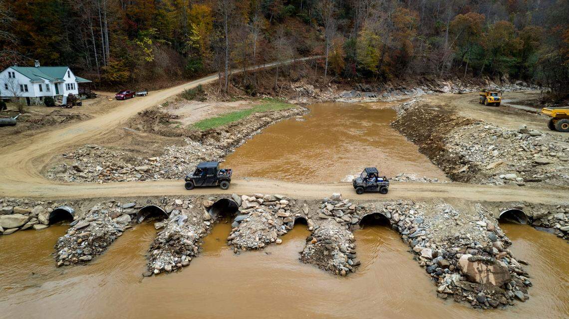 All terrain vehicles cross a makeshift bridge where NCDOT contractors are working to repair and replace a 14-mile stretch of U.S. 19W along the Cane River in Yancey County.