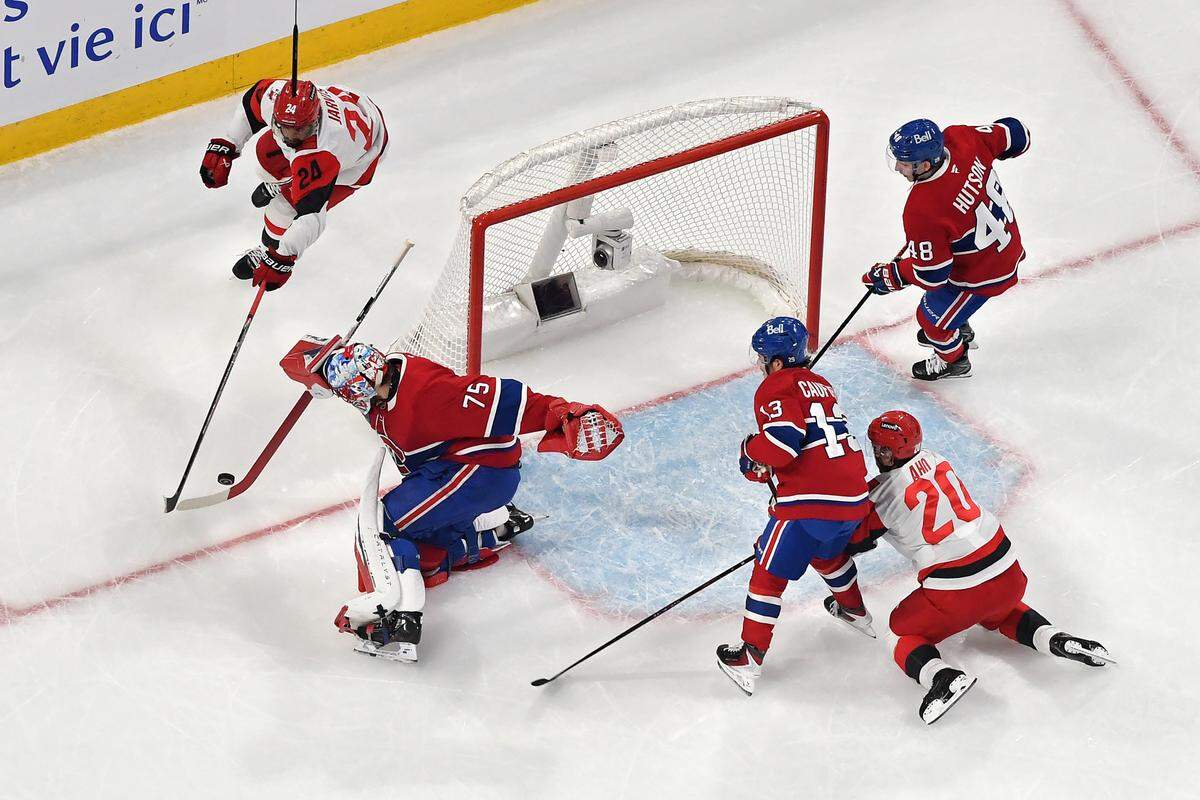 Jakub Dobes #75 of the Montreal Canadiens and Seth Jarvis #24 of the Carolina Hurricanes compete for the puck during the first period in Game Four of the Eastern Conference Final of the 2026 Stanley Cup Playoffs at Bell Centre on May 27, 2026 in Montreal, Quebec, Canada. 