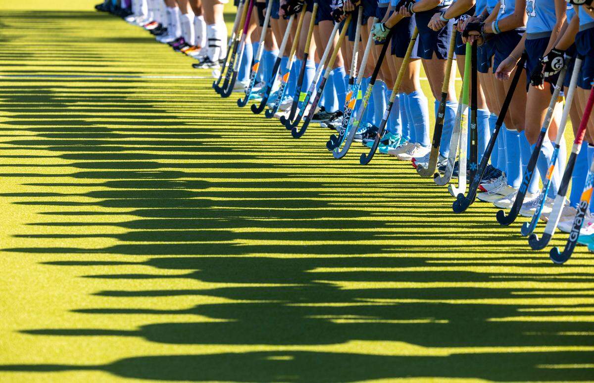 The afternoon sun casts long shadows of the North Carolina field hockey team as they are introduced prior to their game against Northwestern in the NCAA Division I Field Hockey Championship on Sunday, November 19, 2023 at Karen Shelton Stadium in Chapel Hill, N.C.