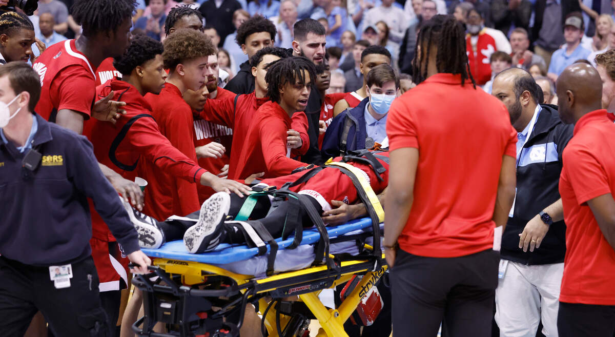 Wolfpack teammates talk to N.C. State’s Terquavion Smith as he is taken off the court after being injured during the second half of N.C. State’s game against UNC at the Smith Center in Chapel Hill, N.C., Saturday, Jan. 21, 2023.