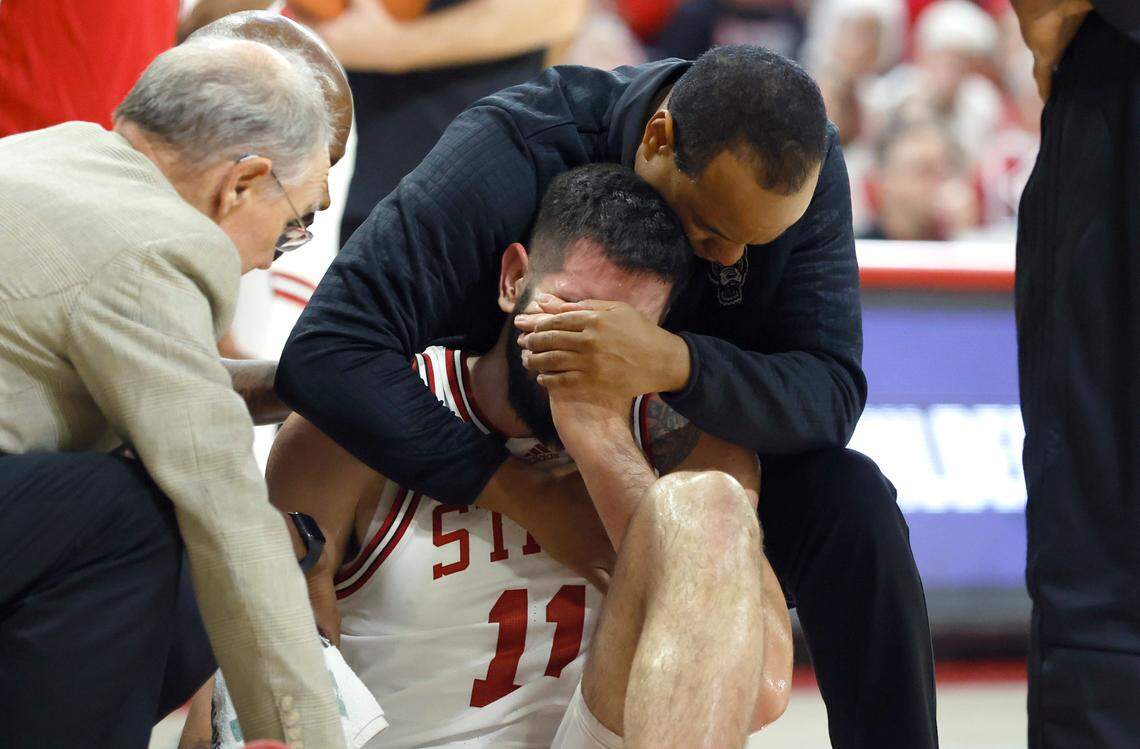 N.C. State head coach Kevin Keatts comforts Dusan Mahorcic (11) after he was injured during the second half of N.C. State’s 94-72 victory over Coppin State at Reynolds Coliseum in Raleigh, N.C., Tuesday, Dec. 6, 2022.