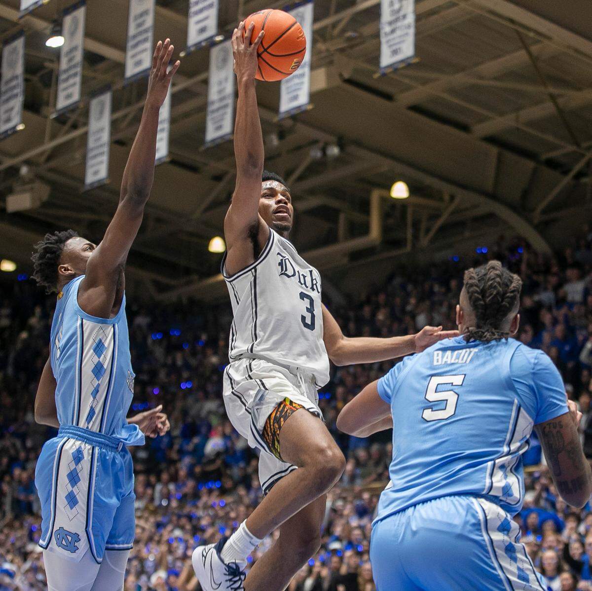 Duke’s Jeremy Roach (3) drives to the basket between North Carolina’s D’Marco Dunn (11) and Armando Bacot (5) in the first half on Saturday, February 4, 2023 at Cameron Indoor Stadium in Durham, N.C. Roach lead all scores with 20 points in the Blue Devils’ 63-57 victory.