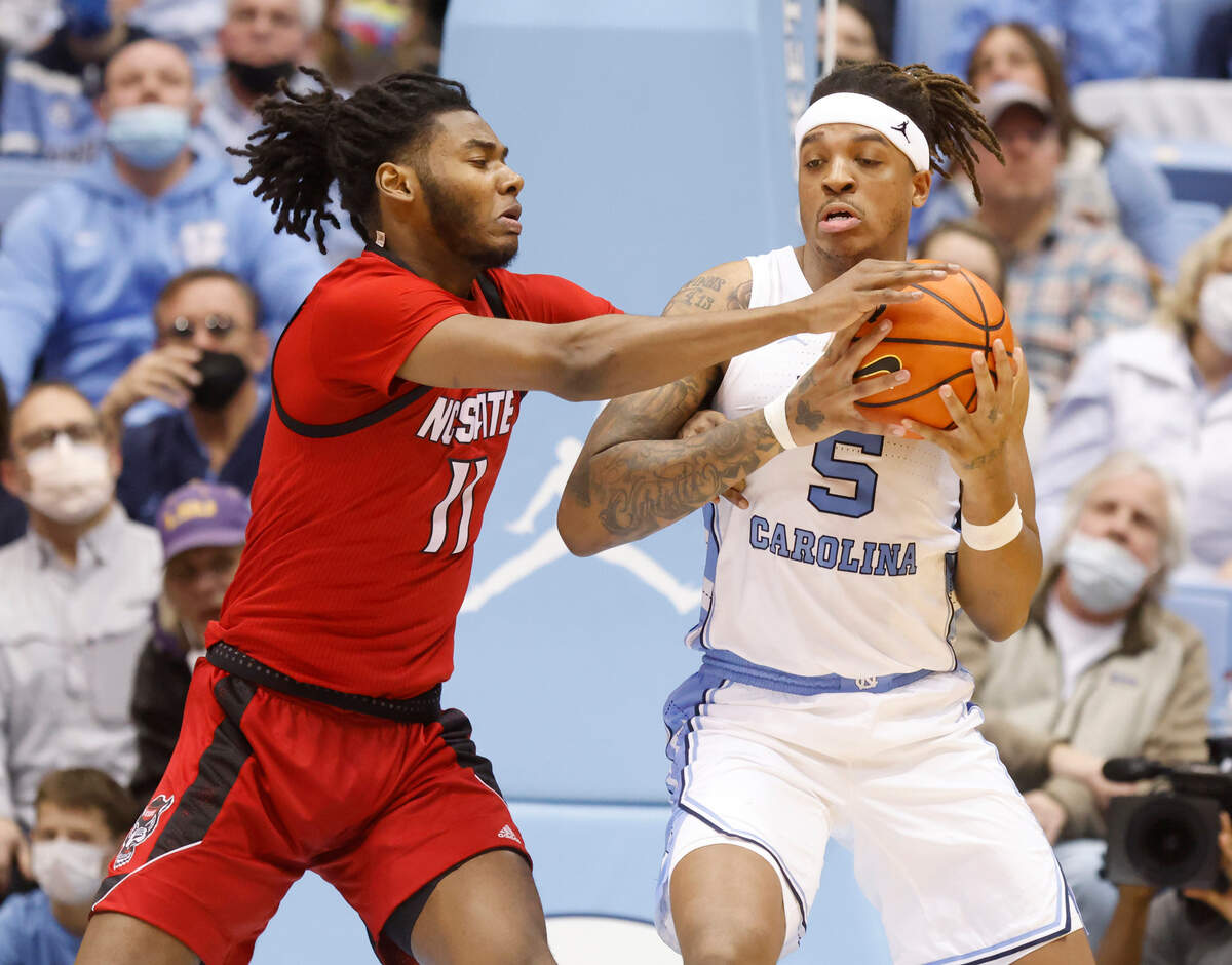 N.C. State’s Jaylon Gibson (11) fights for the ball with North Carolina’s Armando Bacot (5) during the first half of UNC’s game against N.C. State at the Smith Center in Chapel Hill, N.C., Saturday, Jan. 29, 2022.