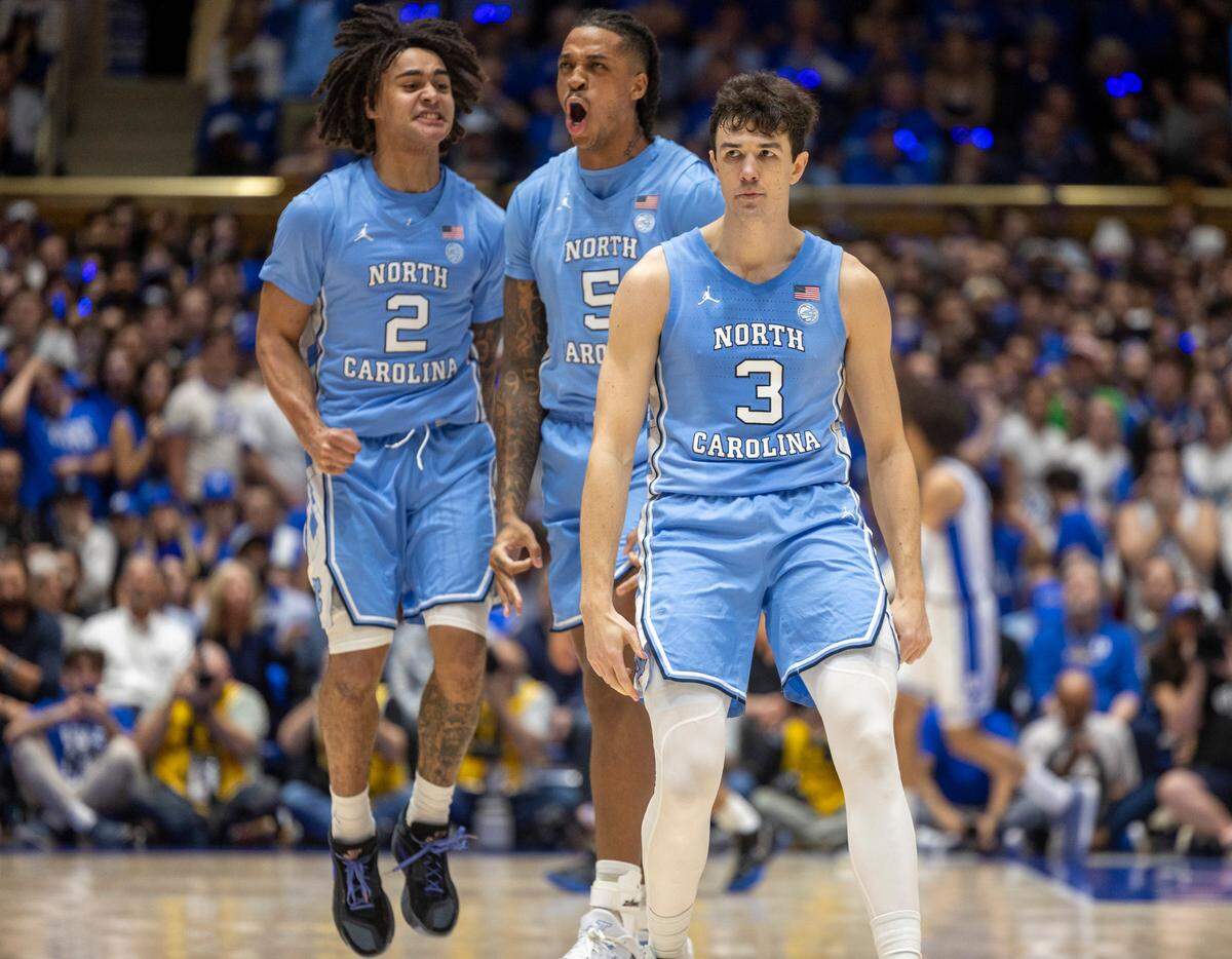 North Carolina’s Cormac Ryan (3), Armando Bacot (5), and Elliot Cadeau (2) react after Ryan hit his third three-point basket in the first half to give the Tar Heels’ a 15-4 lead over Duke on Saturday, March 9, 2024 at Cameron Indoor Stadium in Durham, N.C.