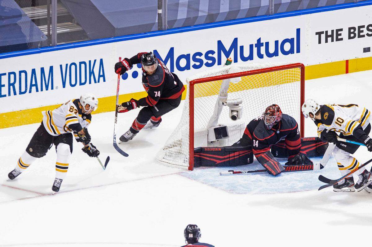 Carolina Hurricanes goaltender Petr Mrazek (34) saves a shot from Boston Bruins forward Brad Marchand (63) as Hurricanes defenseman Jaccob Slavin (74) looks on during the second period of a NHL Eastern Conference Stanley Cup playoff game in Toronto, on Saturday, Aug. 15, 2020.