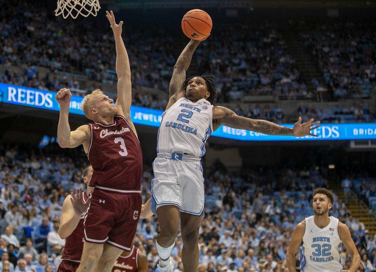 North Carolina’s Caleb Love (2) drives against College of Charleston’s Dalton Bolon (3) for a dunk during the first half on Friday, November 11, 2022 at the Smith Center in Chapel Hill, N.C.
