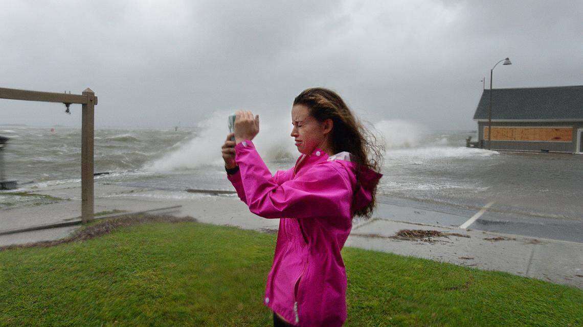 Victoria Baughman shoots video of the waves from the Cape Fear River crashing into the bulkhead at the end of Howe Street in Southport, N.C. Saturday, October 8, 2016 as Hurricane Matthew moved into southeastern N.C..