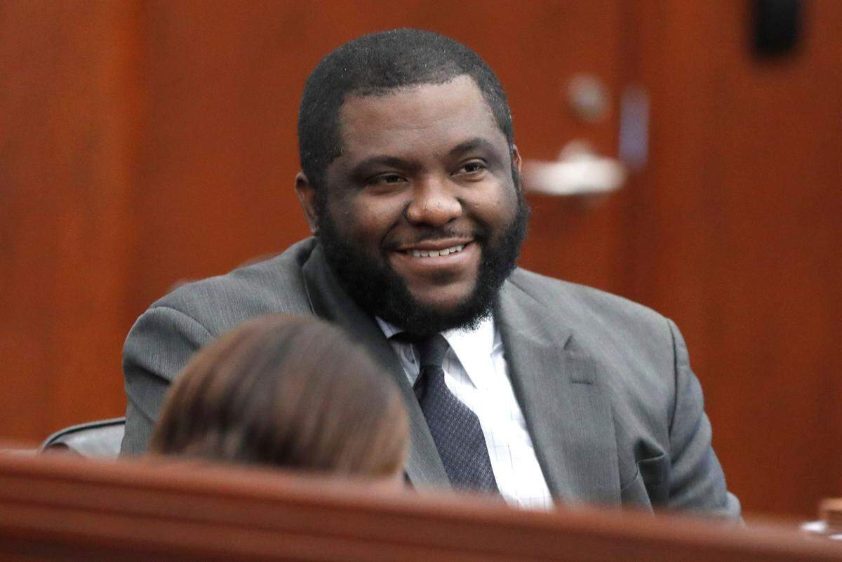 Chief Public Defender Deonte’ L. Thomas smiles while talking with Kailey Morgan, an intern from North Carolina Prisoner Legal Services, before the start of the day’s proceedings in the trial of Kendrick Gregory at the Wake County Justice Center in Raleigh, N.C., Wednesday, July 28, 2021.