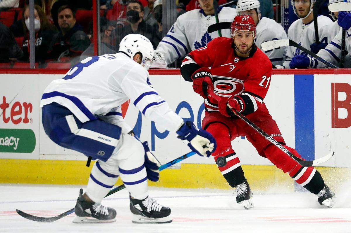 Carolina Hurricanes’ Nino Niederreiter (21) clears the puck past Toronto Maple Leafs’ Jake Muzzin (8) during the second period of an NHL hockey game in Raleigh, N.C., Monday, Oct. 25, 2021. (AP Photo/Karl B DeBlaker)