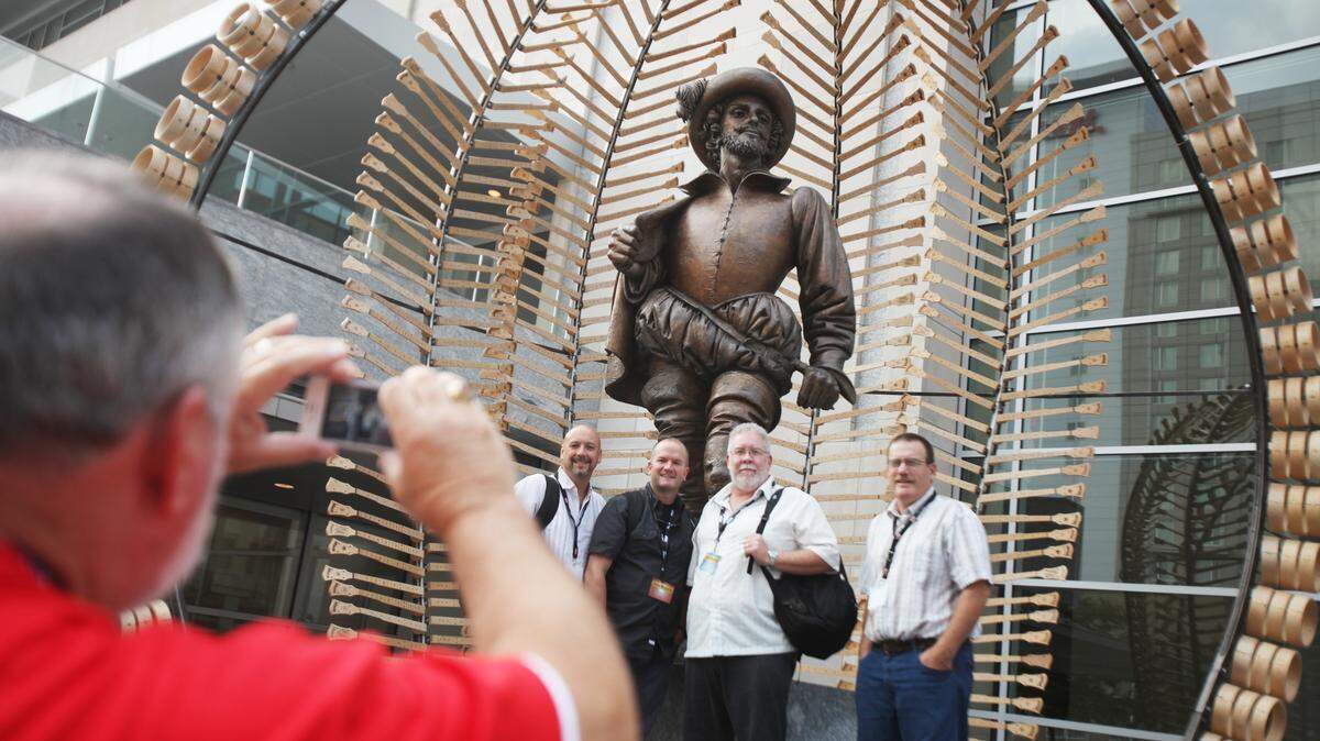 Willie T. Sorrell III, left, takes a photo of bluegrass band, None of the Above from Pinnacle, NC, in front of the Sir Raleigh Walter statue in 2014. Sir Walter remains a tempting snapshot opportunity downtown.