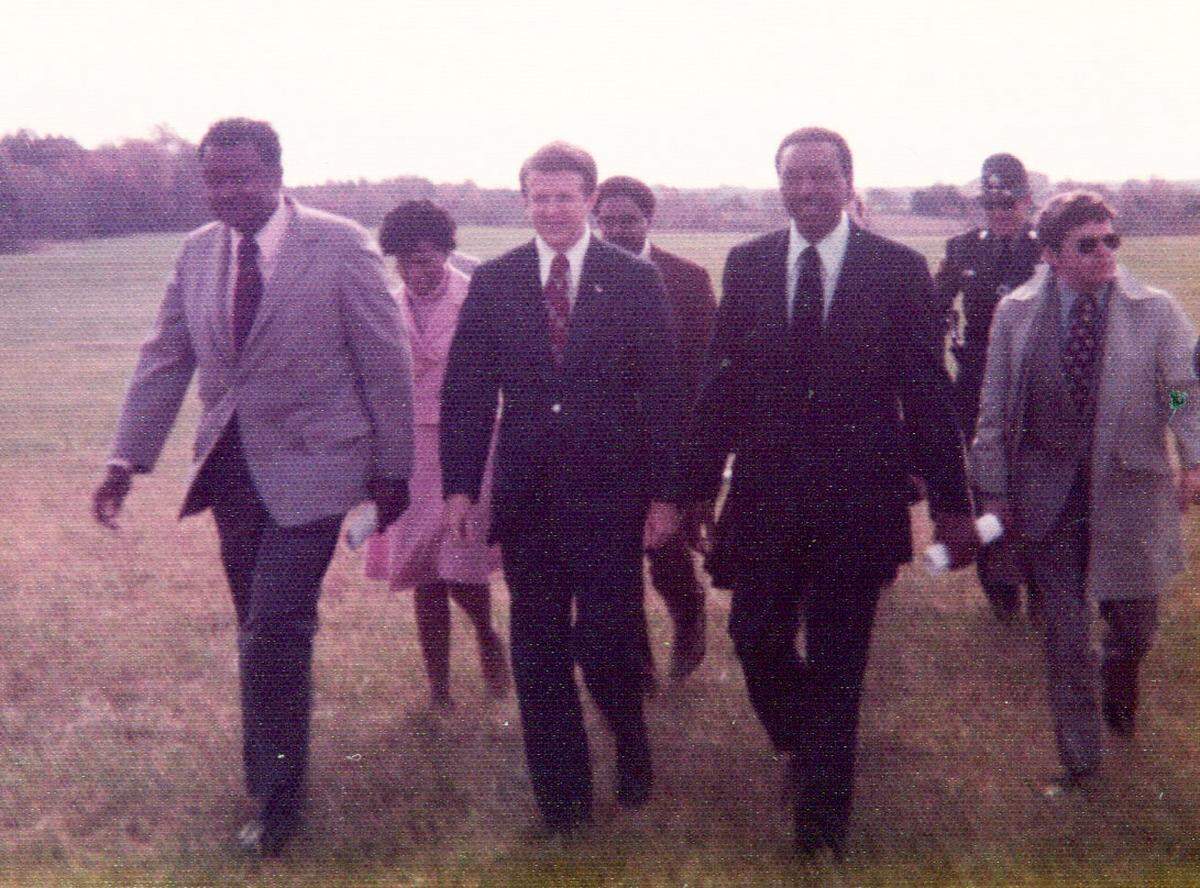 Floyd McKissick, right, and Governor Jim Holshouser, center, on their way to the groundbreaking celebration of Soul City in Warren County, North Carolina on Nov. 9, 1973.