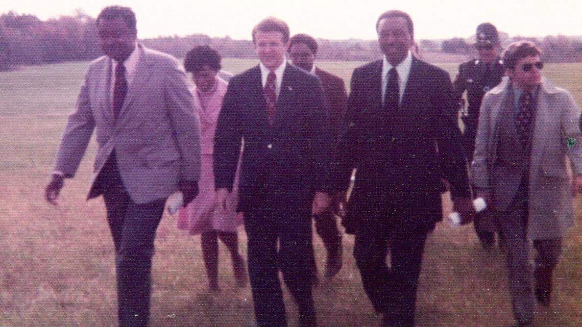 Floyd McKissick, right, and Governor Jim Holshouser, center, on their way to the groundbreaking celebration of Soul City in Warren County, North Carolina on Nov. 9, 1973.