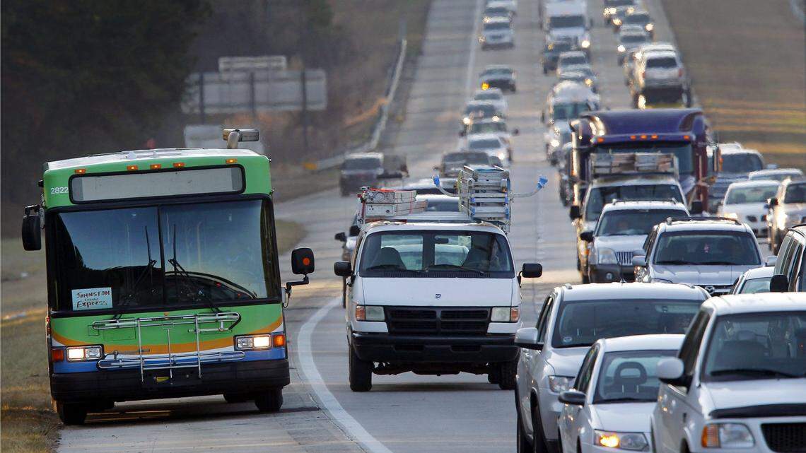 A TTA bus, with a “Johnston Express” sign in the front window, drives up the shoulder as traffic slows to a crawl on I-40 inbound from Johnston County and southern Wake County during morning rush-hour traffic.