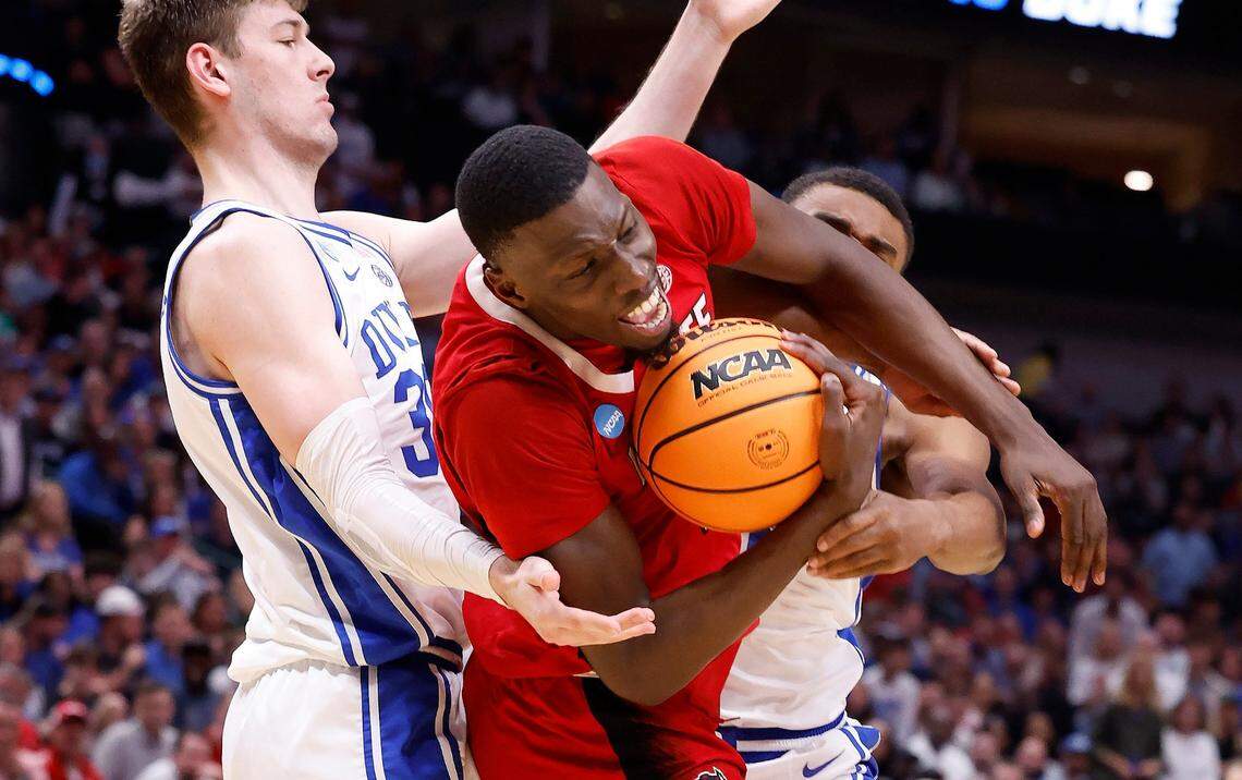 N.C. State’s Mohamed Diarra (23) pulls in the rebound from Duke’s Kyle Filipowski (30) and Jaylen Blakes (2) during the first half of N.C. State’s game against Duke in their NCAA Tournament Elite Eight matchup at the American Airlines Center in Dallas, Texas, Sunday, March 31, 2024.