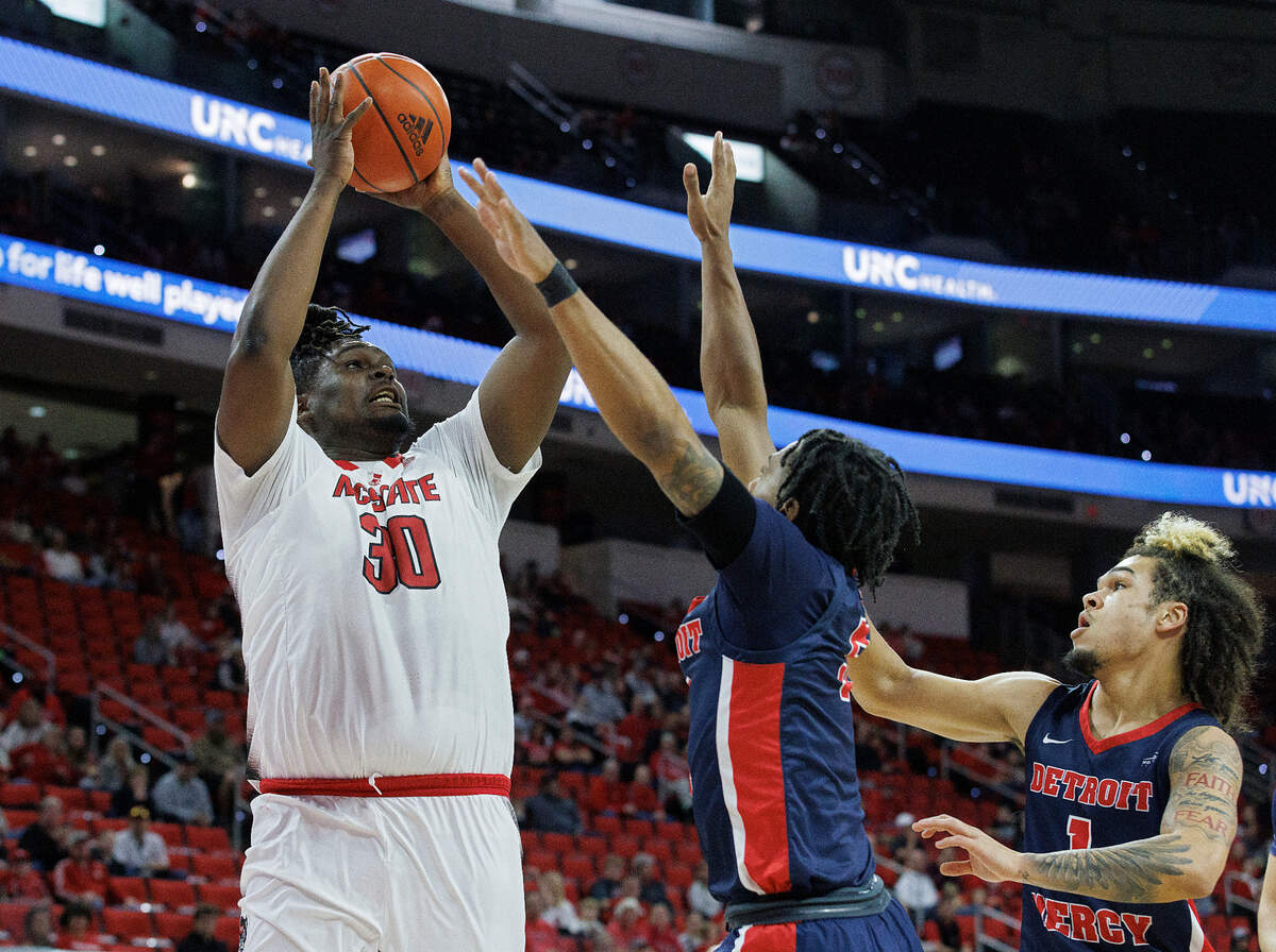 N.C. State’s DJ Burns Jr. shoots over Detroit’s Kyle LeGreair and Mak Manciel during the first half of the Wolfpack’s 83-66 win on Saturday, Dec. 23, 2023, at PNC Arena in Raleigh, N.C.