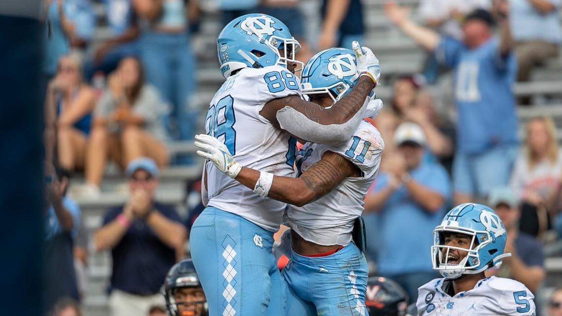 North Carolina’s Josh Downs (11) celebrates with teammate Kamari Morales (88) after scoring on a 19-yard pass reception from quarterback Drake Maye in the third quarter to give the Tar Heels’ a 24-21 lead on Saturday, November 5, 2022 at Scott Stadium in Charlottesville, Va.