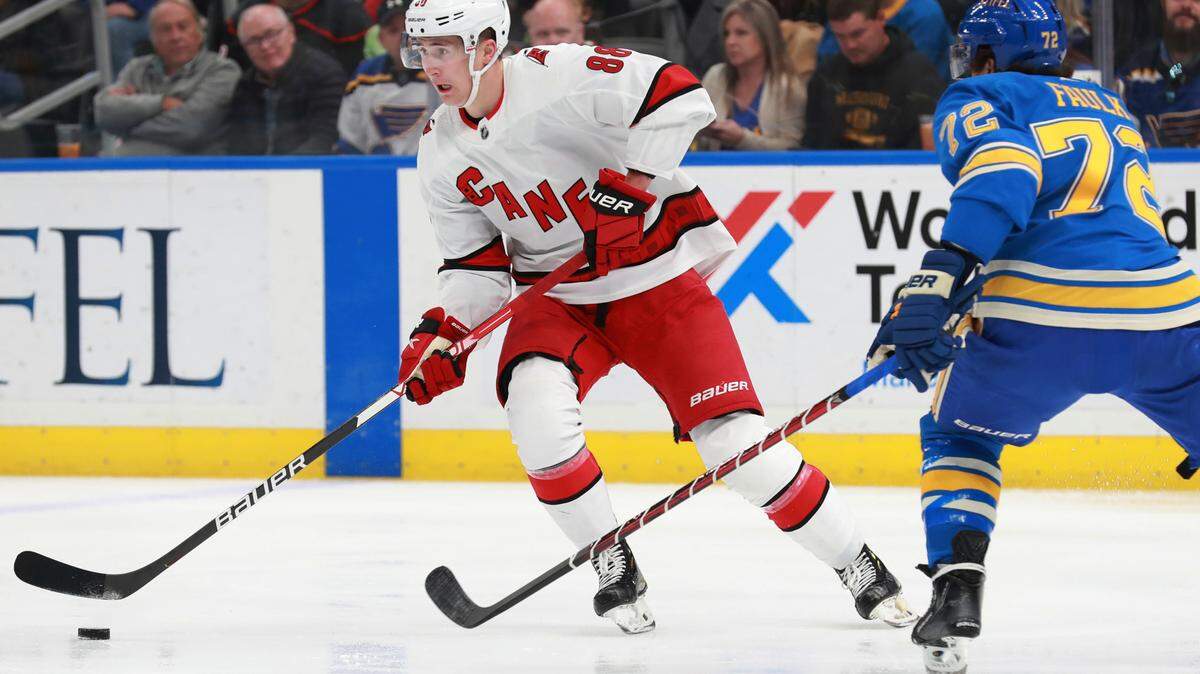 Carolina Hurricanes’ Martin Necas (88) works the puck against St. Louis Blues’ Justin Faulk (72) during the first period of an NHL hockey game against the St. Louis Blues on Saturday, March 26, 2022 in St. Louis. (AP Photo/Michael Thomas)