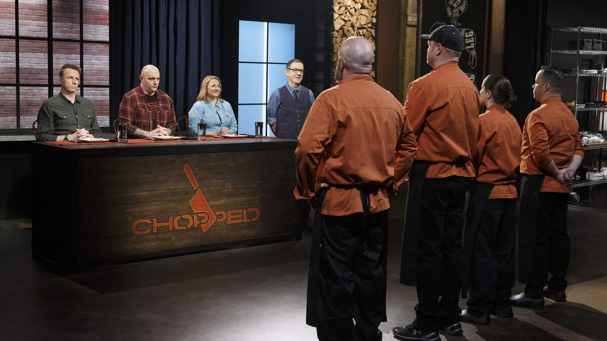 Judges, from left, Marc Murphy, Chris Santos and Elizabeth Karmel and host Ted Allen face chefs Christopher Prieto, Melanie Dunia, Adam Hughes and Jerry Stephenson during the appetizer round tasting on “Chopped, Grill Masters” on Aug. 7, 2018.