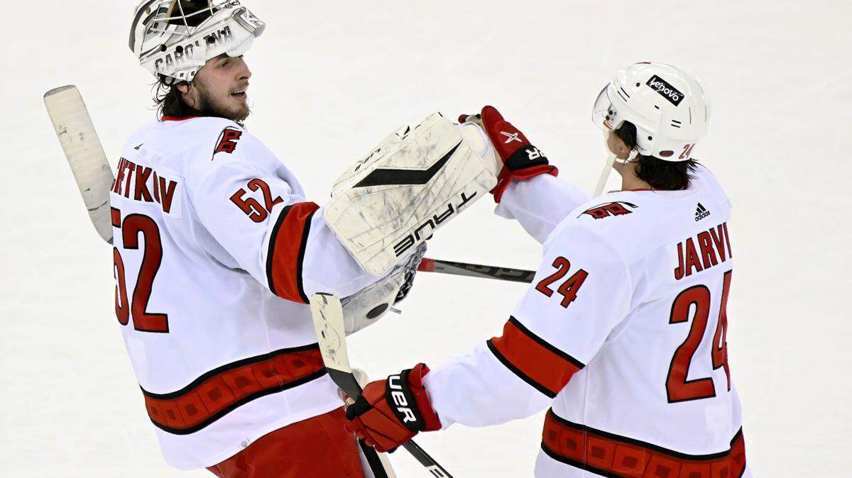 Carolina Hurricanes goaltender Pyotr Kochetkov (52) celebrates with center Seth Jarvis (24) after Jarvis scored the winning goal during the overtime period of an NHL hockey game to defeat the New Jersey Devils 3-2 Saturday, April 23, 2022, in Newark, N.J. (AP Photo/Bill Kostroun)