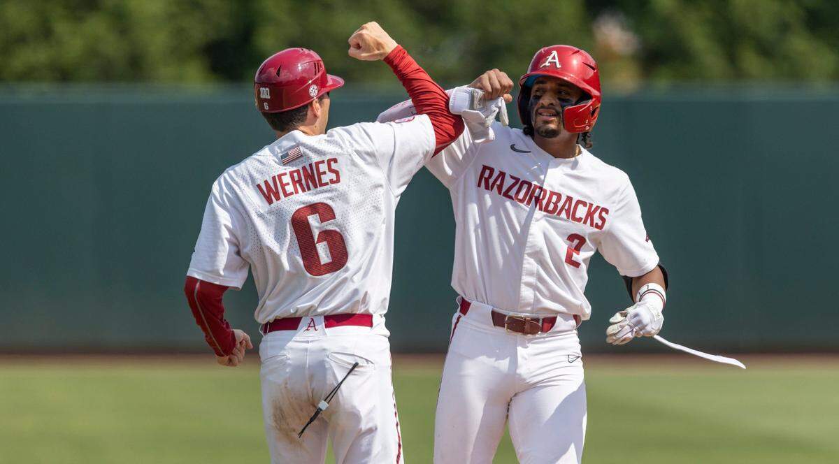 Arkansas assistant coach Bobby Wernes (6) congratulates Jalen Battles (2) after he connected for a double and scored one run in the fourth inning against North Carolina in game two of their NCAA Super Regional series on Sunday, June 12, 2022 at Boshamer Stadium in Chapel Hill, N.C.