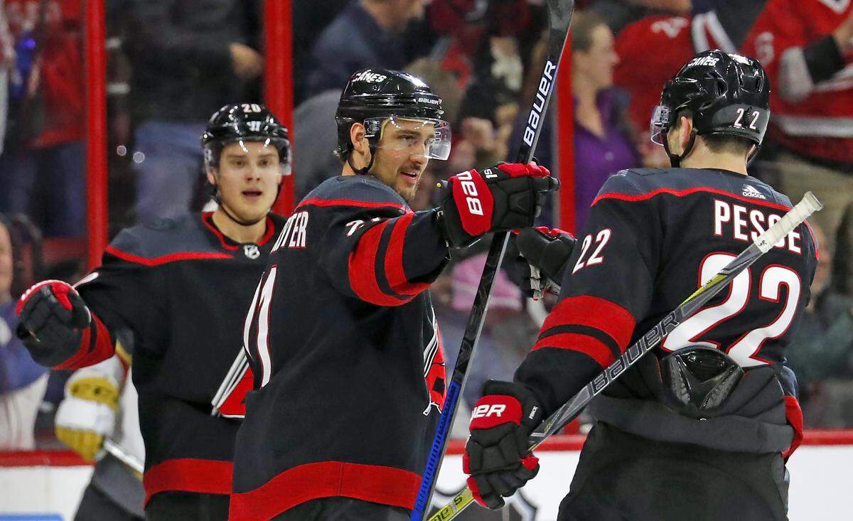 Carolina Hurricanes’ Nino Niederreiter, center, celebrates his goal with teammates Sebastian Aho, left, and Brett Pesce (22) during the first period of an NHL hockey game against the Vegas Golden Knights, Friday, Feb. 1, 2019, in Raleigh, N.C.