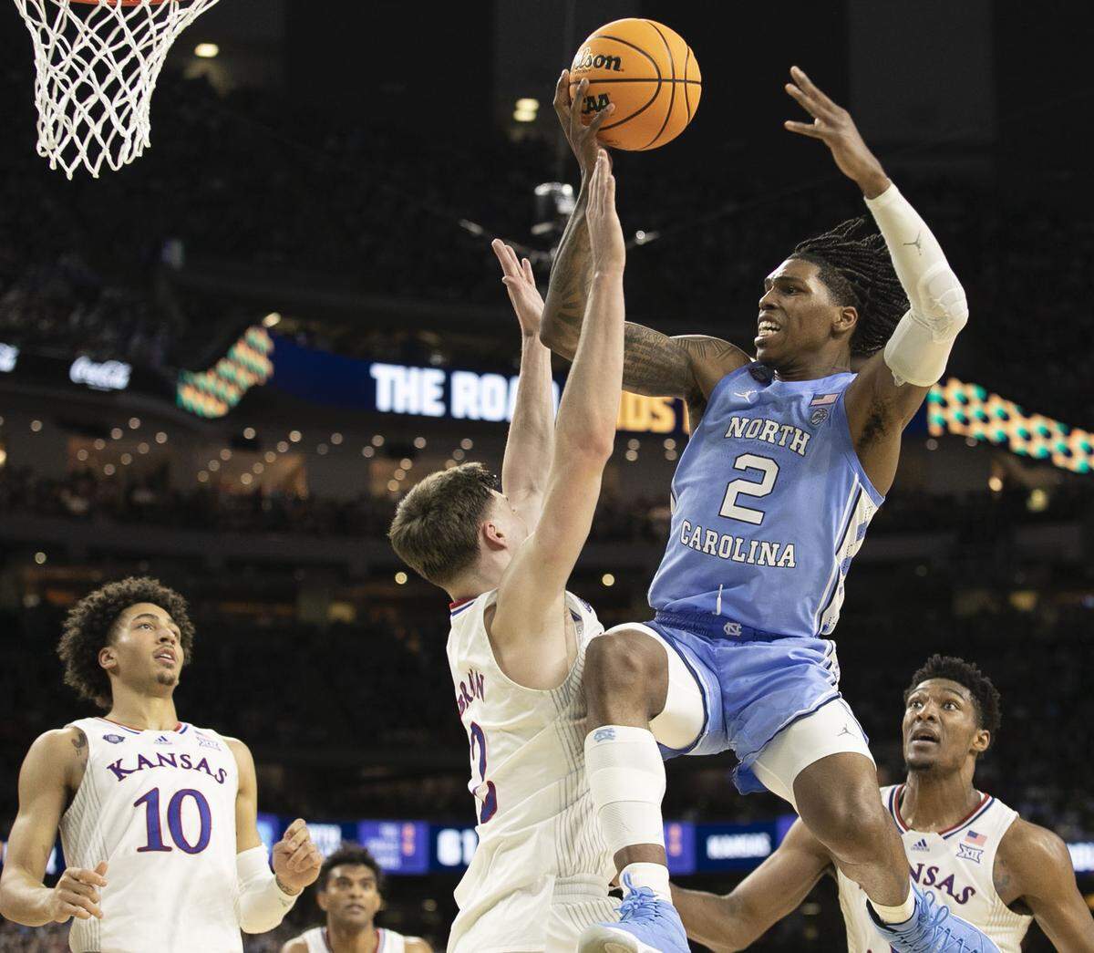 North Carolina’s Caleb Love (2) works to penetrate the Kansas defense of Christian Braun (2) during the second half in the NCAA Championship game on Monday, April 4, 2022 at Caesars Superdome in New Orleans,