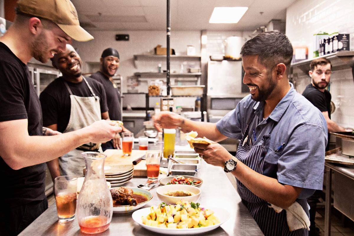 Vidrio chef Saif Rahman, right, passes out bread to kitchen staff during a short break during dinner service on Tuesday, April 26, 2022, to break fast. Rahman fasts for 14 hours daily during the month of Ramadan and is not able to break his fast until sundown which occurs during dinner service.