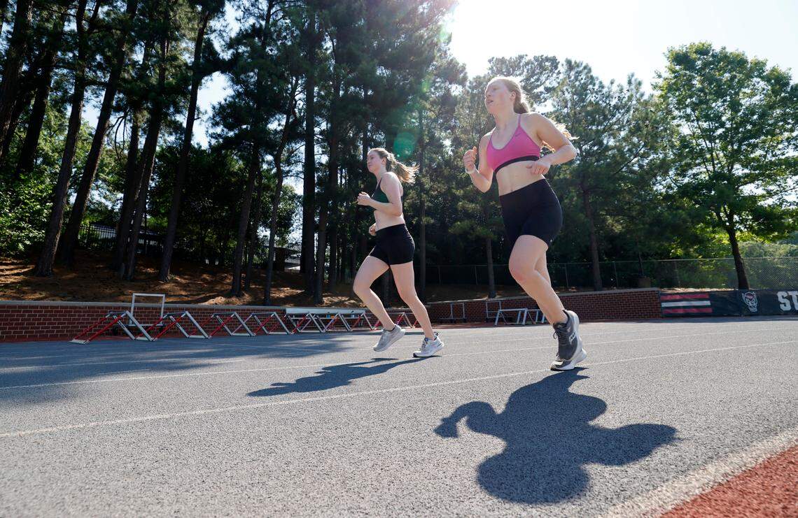 Grace Palmgren, left, and her sister Ava work out at N.C. State’s Paul Derr Track and Field facility in Raleigh, N.C., Wednesday, June 26, 2024. The two got to the track at 9:30 and ran drills in the heat. They put on sunscreen and hydrated often during their training. “It’s a good way to start the day” said Grace.