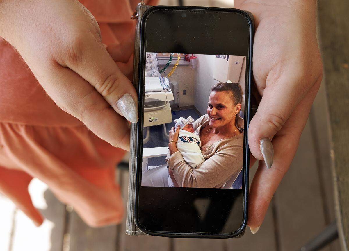 Nicole Holliday, photographed at her home in Wake Forest on Friday, April 17, 2026, shows a photograph of her mother, Victoria Benhoff, holding a grandchild. Benhoff died in March 2025 after ingesting fentanyl.