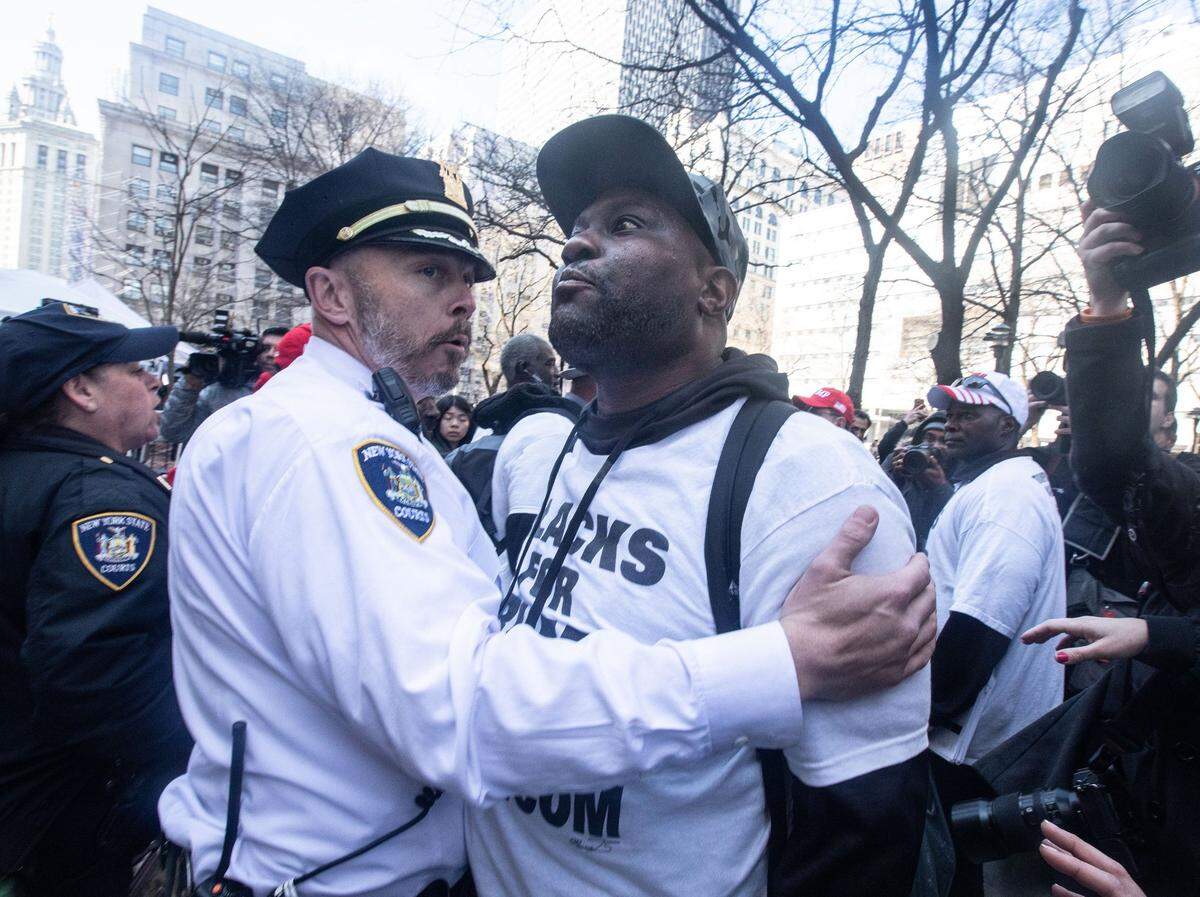 A pro-Donald Trump protestor is held back from engaging with an anti-Trump protestor across the street from the Manhattan Criminal Courthouse April 4, 2023.