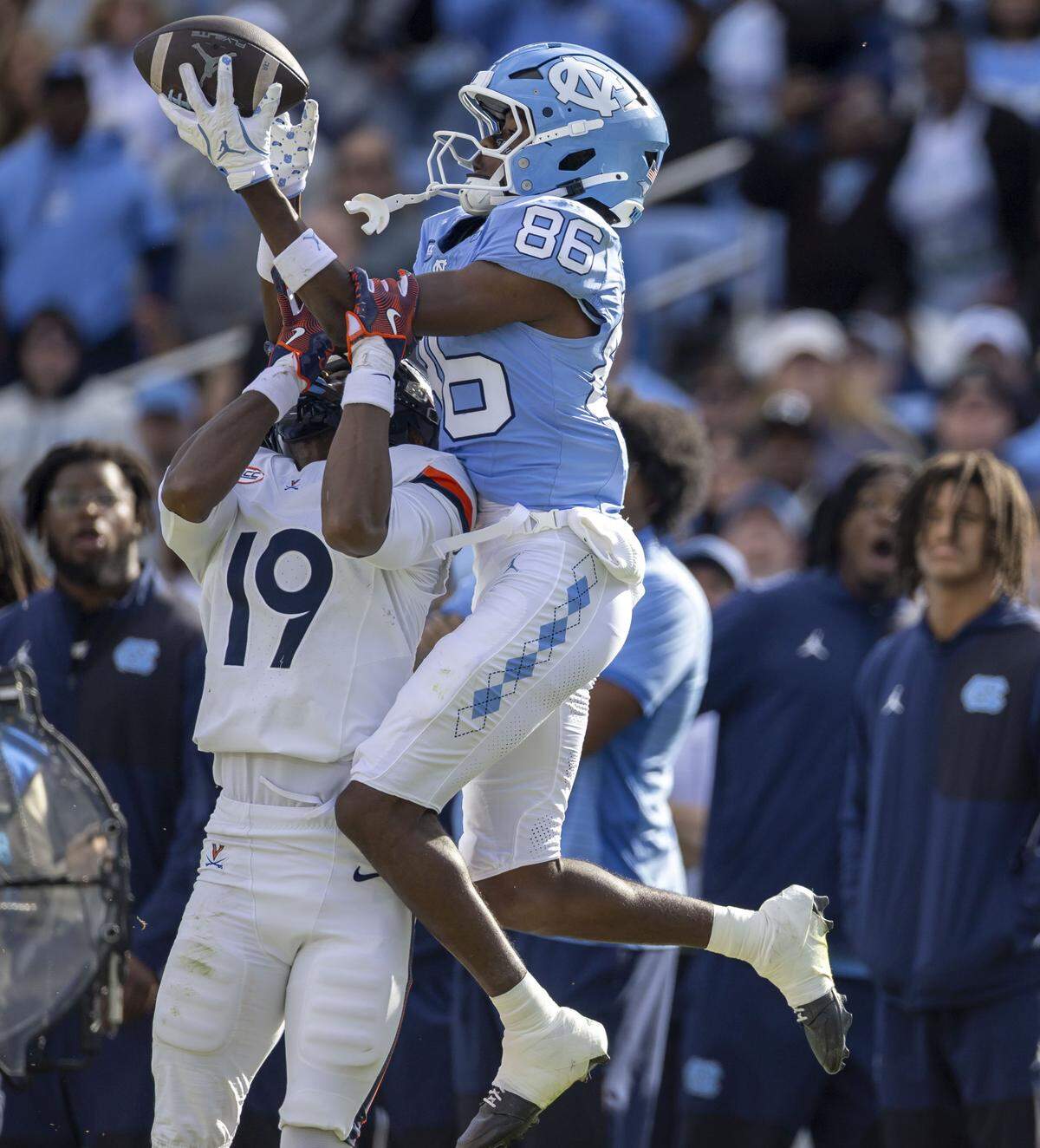 Virginia cornerback Emmanuel Karnley (19) defends North Carolina wide receiver Madrid Tucker (86) as he works to pull in a pass from Gio Lopez (7) on the Tar Heels final drive in the fourth quarter on Saturday, October 25, 2025 at Kenan Stadium in Chapel Hill, N.C.  Tucker was unable to maintain control, Virginia safety Antonio Clary intercepted the ball forcing overtime.  