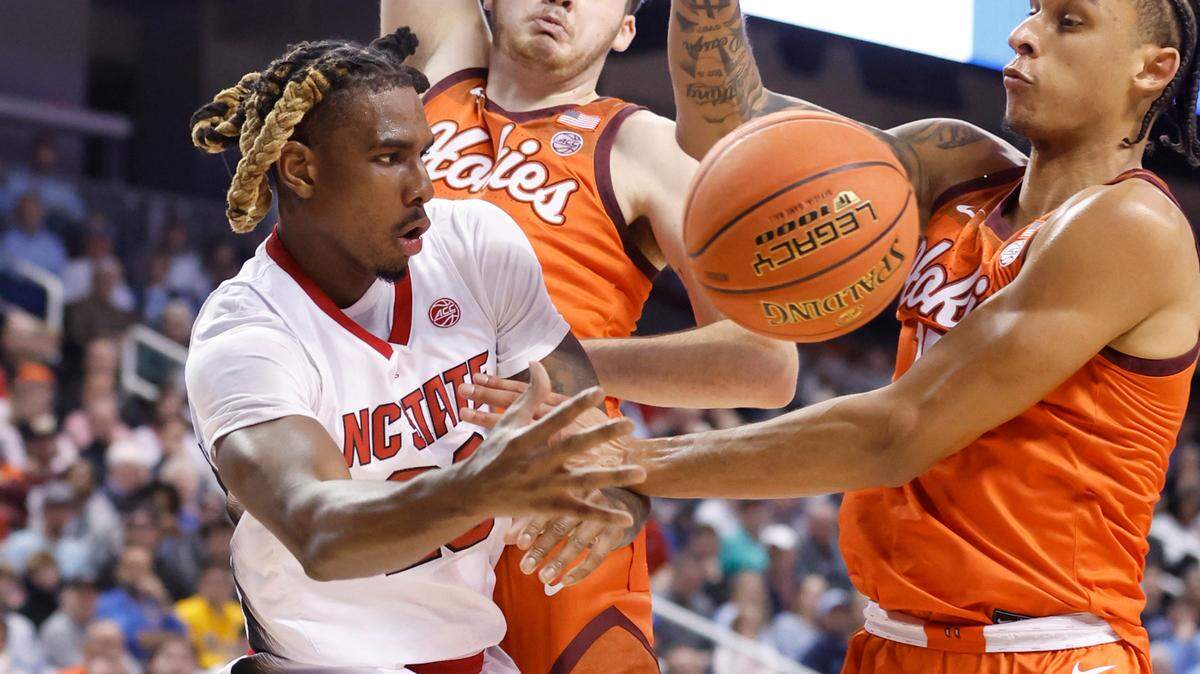 N.C. State’s Greg Gantt (23) passes around Virginia Tech’s Grant Basile (21) and Lynn Kidd (15) during the first half of N.C. State’s game against Virginia Tech in the second round of the ACC Men’s Basketball Tournament in Greensboro, N.C., Wednesday, March 8, 2023.