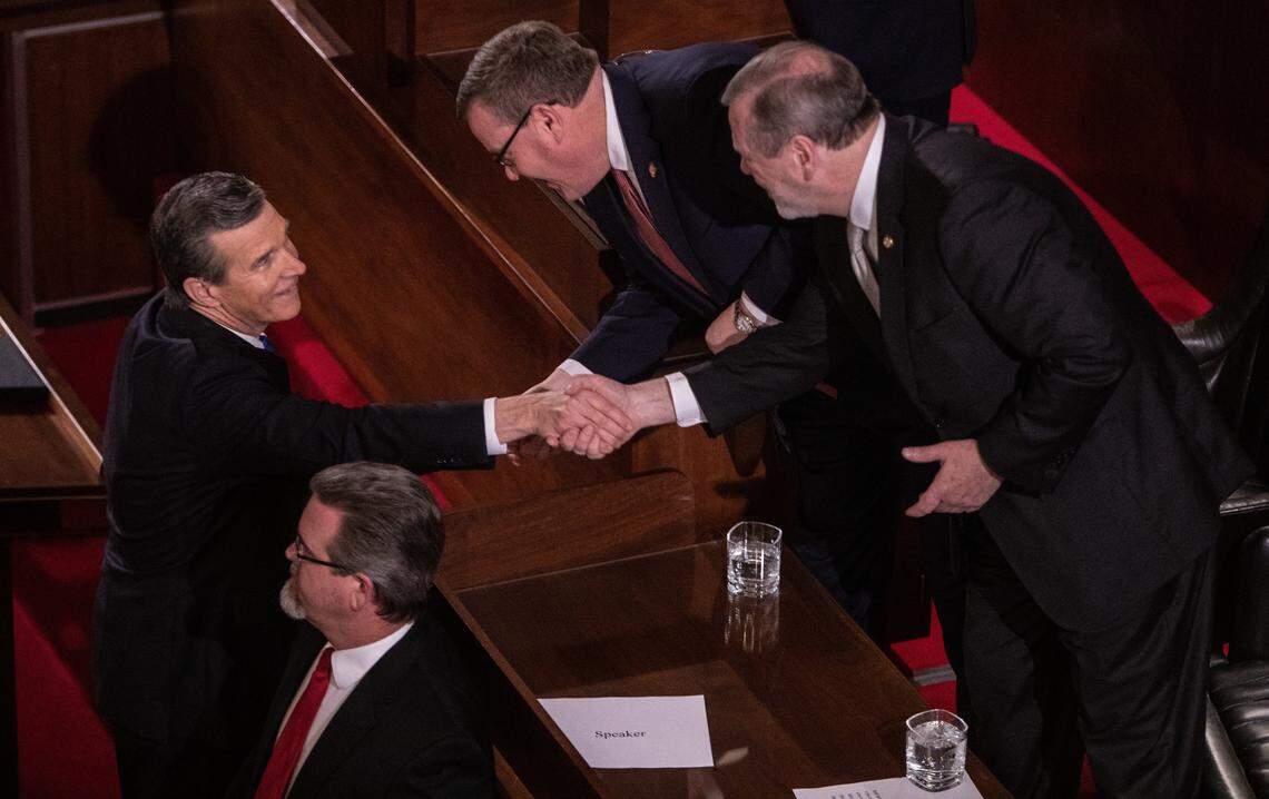Gov. Roy Cooper, left, shakes hands with House Speaker Tim Moore, center and Senate Leader Phil Berger prior to Cooper’s biennial State of the State address to a joint session of the General Assembly at the Legislative Building Monday evening, Feb. 26, 2019.