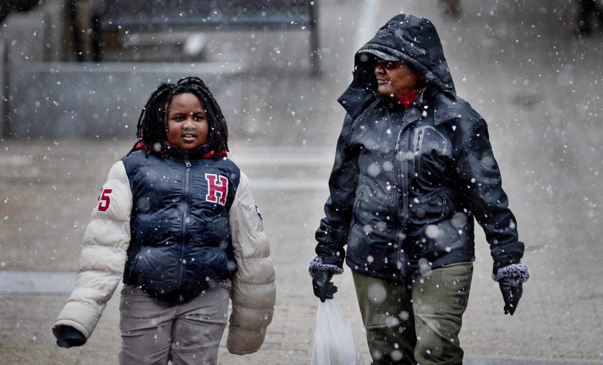 Zayvion Harper, 7, and his grandmother Candy Harper walk home from the store as snow falls in downtown Raleigh, Wednesday morning, Feb. 19, 2025.