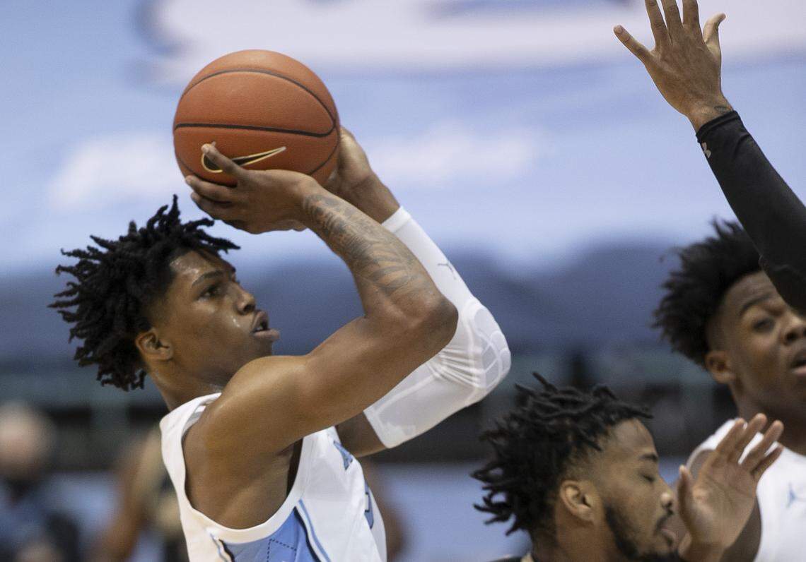 North Carolina’s Caleb Love (2) launches a three-point shot during the first half against the College of Charleston defense on Wednesday, November 25, 2020 at the Smith Center in Chapel Hill, N.C. Love, a freshman, lead all scores with 17 points in the Tar Heels’ 79-60 victory.
