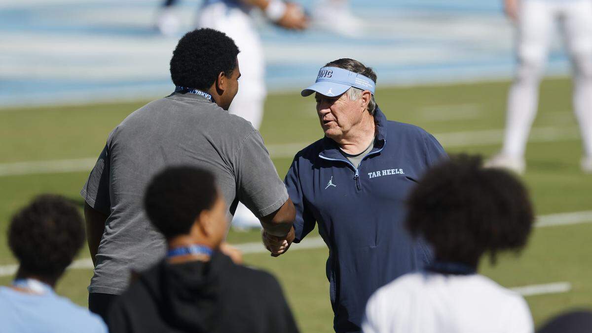 North Carolina head coach Bill Belichick greets people and poses for photos with them as the team warms up before UNCÕs game against Clemson at Kenan Stadium in Chapel Hill, N.C., Sat. Oct. 4, 2025.