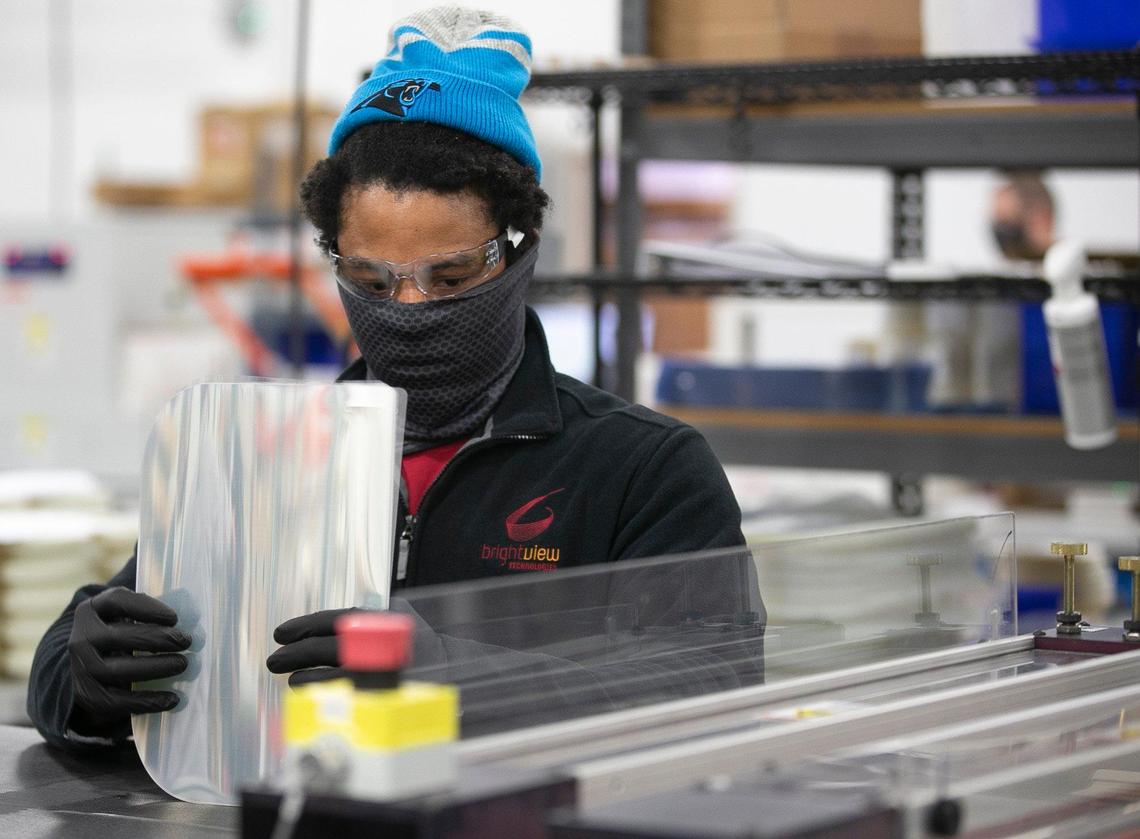 Bright View technologies employee Rasheed Nowell operates a dye cutting machine that produces face shields on Thursday, November 19, 2020 in Durham, N.C.