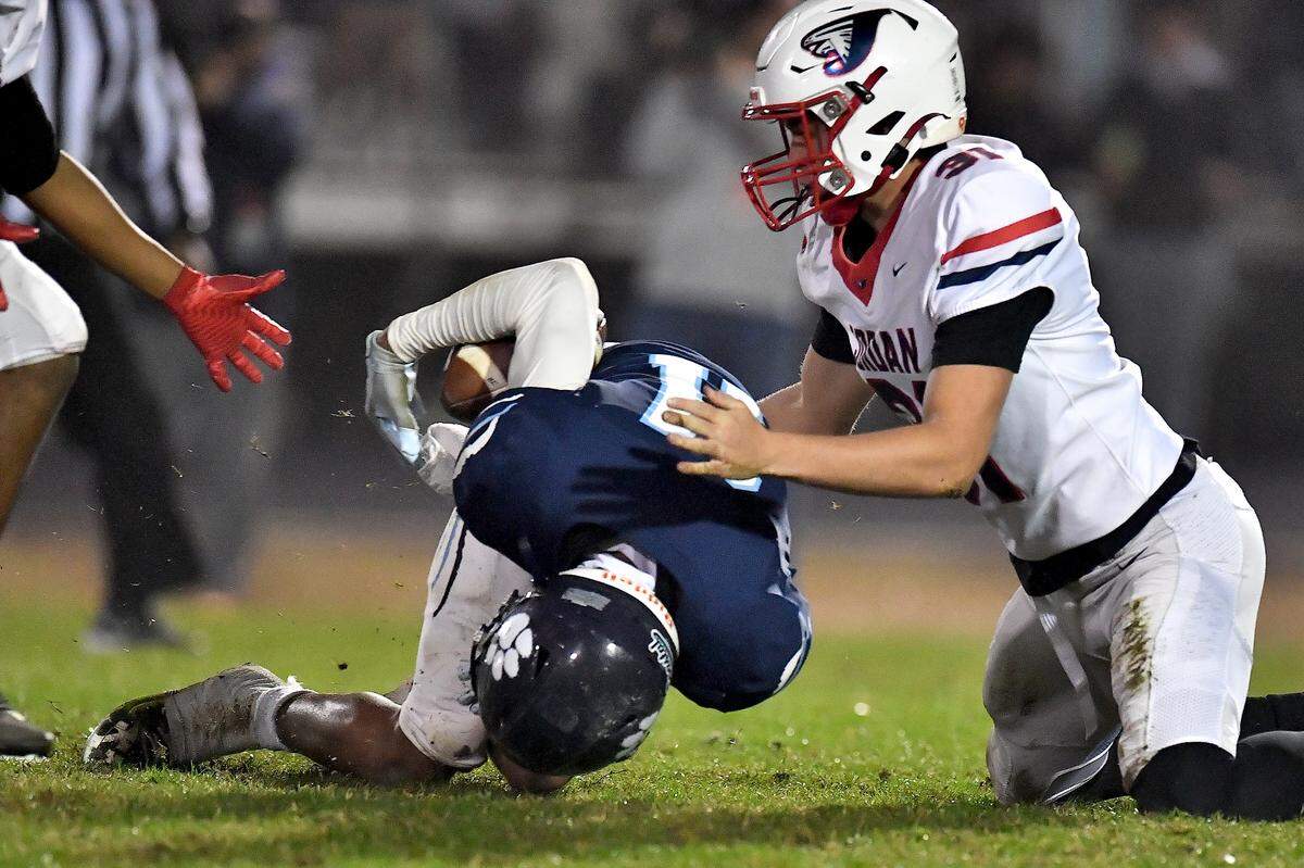 Millbrook strong safety Cairo Williams (11) recovers the ball against Jordan punter Asher Holland (31) during the first half. The Millbrook Wildcats and the Jordan Falcons met in the third round of the NCHSAA 8A football playoffs in Raleigh, N.C. on November 21, 2025.