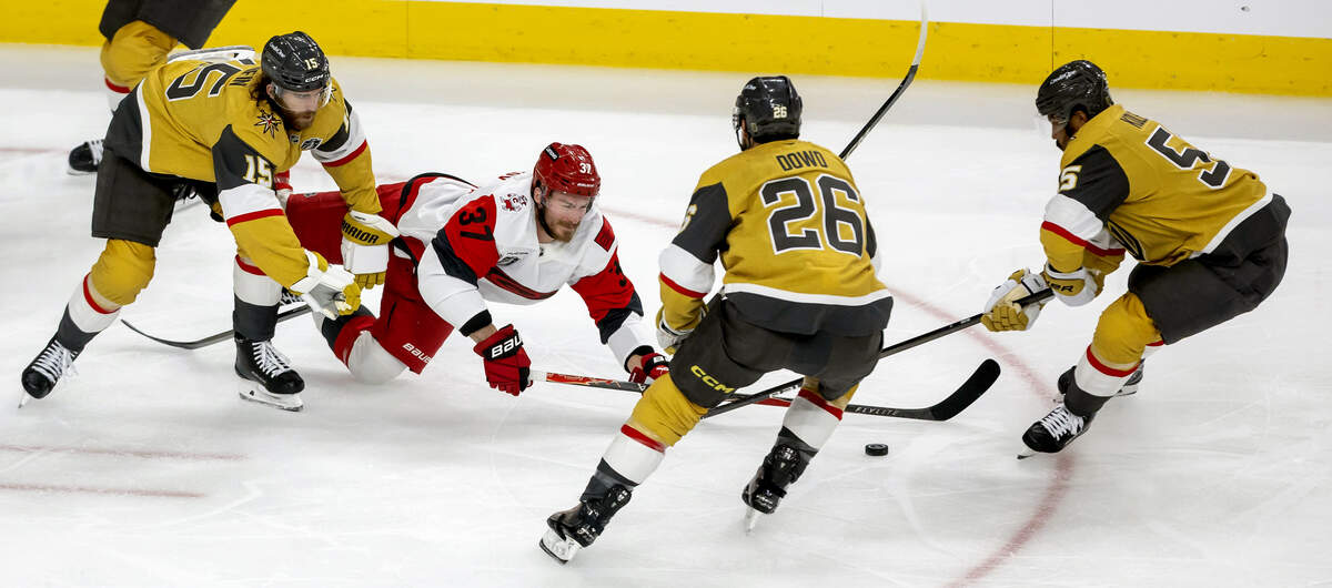 Vegas defenseman Noah Hanifin (15) checks Carolina Hurricanes right wing Andrei Svechnikov (37) to the ice in the first period, as teammates Noah Hanifin (15) and Keegan Kolesar (55) take control of the puck in Game 3 of the Stanley Cup Final, on Saturday, June 6, 2026 at T-Mobile Arena in Las Vegas, NV.
