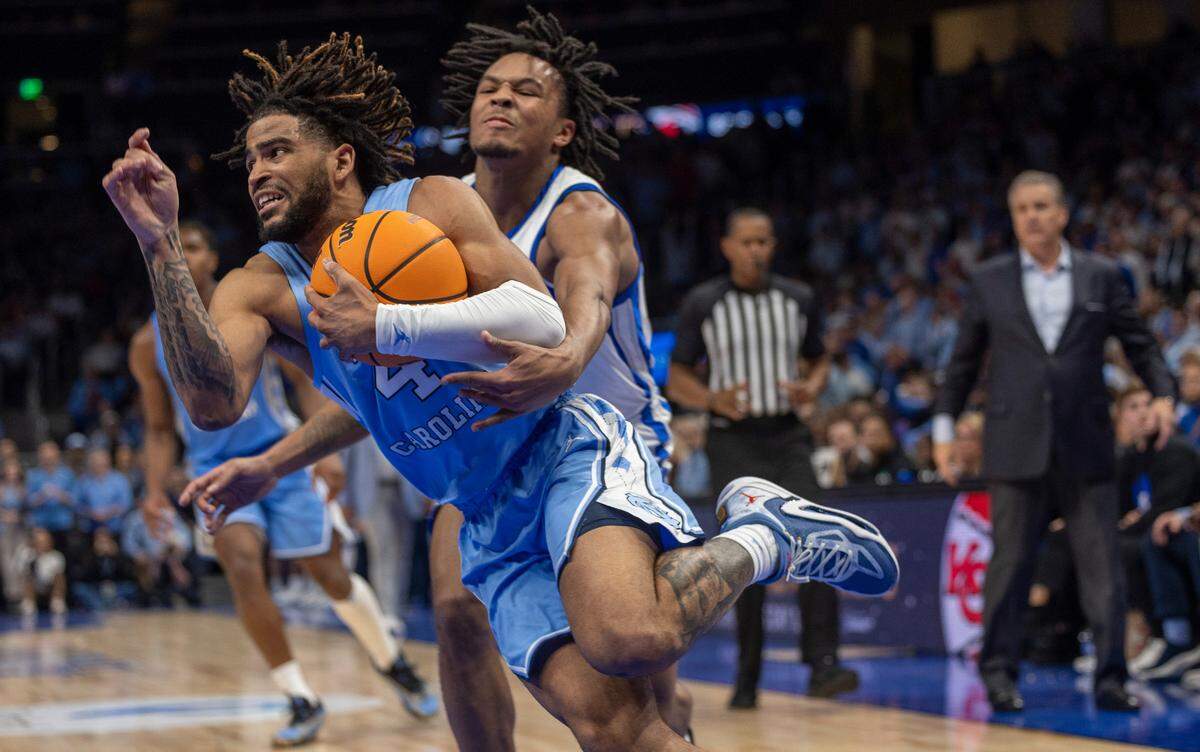 Kentucky’s D.J. Wagner (21) tries to stop North Carolina’s R.J. Davis (4) in the first half on Saturday, December 16, 2023 at State Farm Arena in Atlanta, Georgia.
