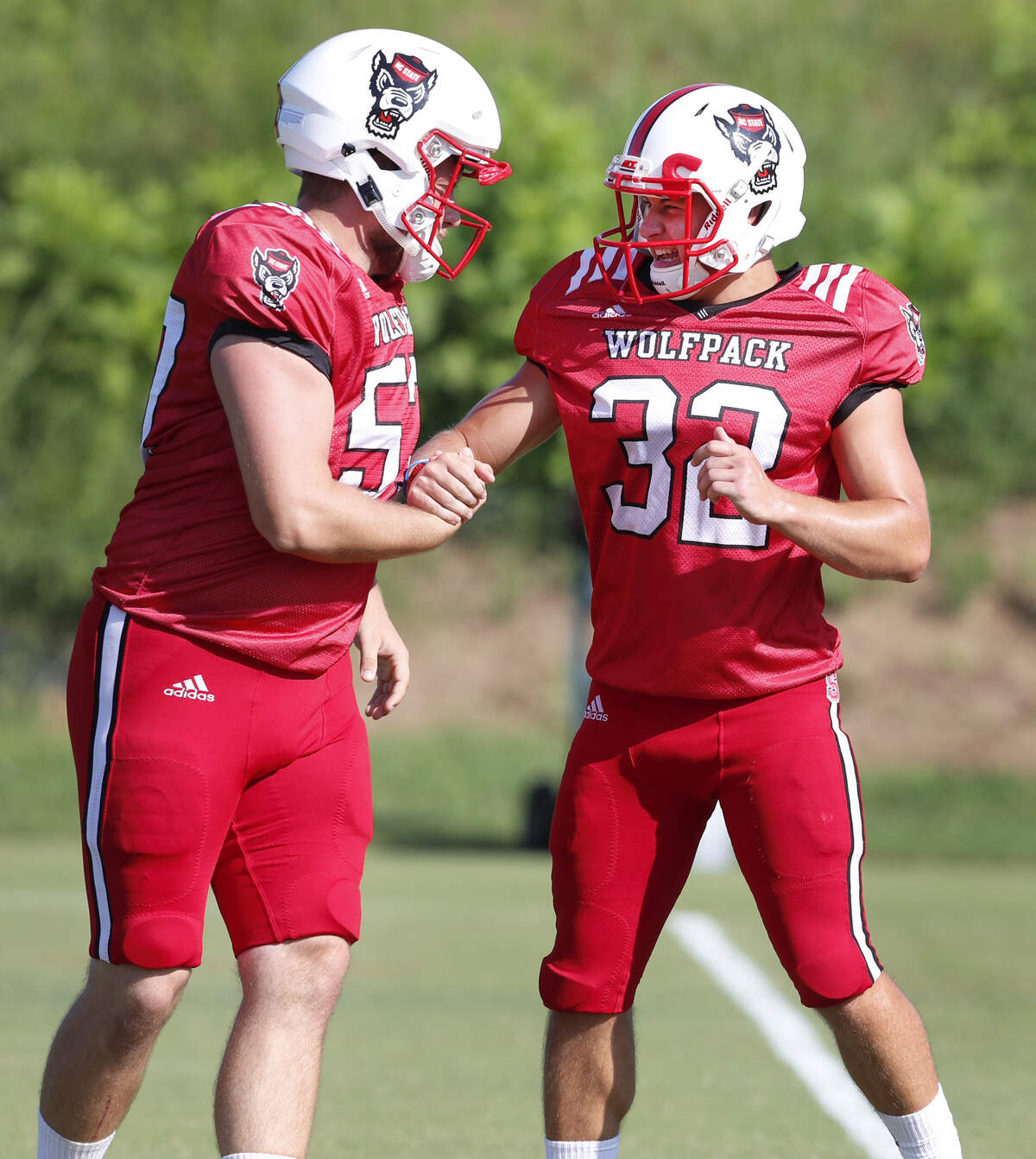 N.C. State’s Christopher Dunn (32), right, celebrates making a field goal with Tyler Griffiths (57) during the Wolfpack’s practice in Raleigh Thursday, August 9, 2018.